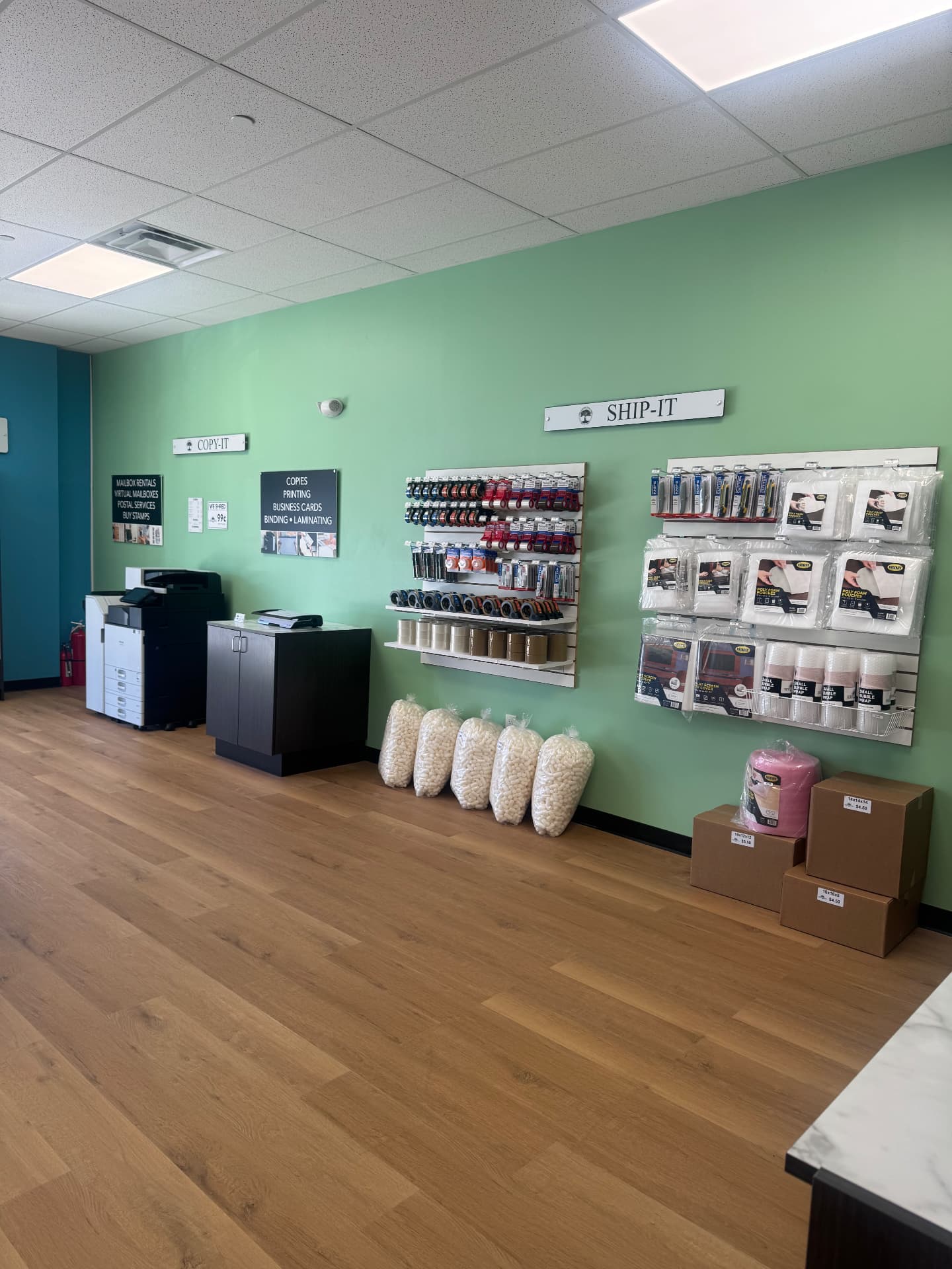 Showroom wall with the copier, packing supplies and boxes at The Connection Tree Ship and Print in Freehold, New Jersey